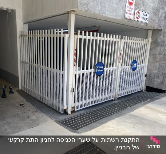שני מברגות ומטר על רצפה ליד שער מתכת